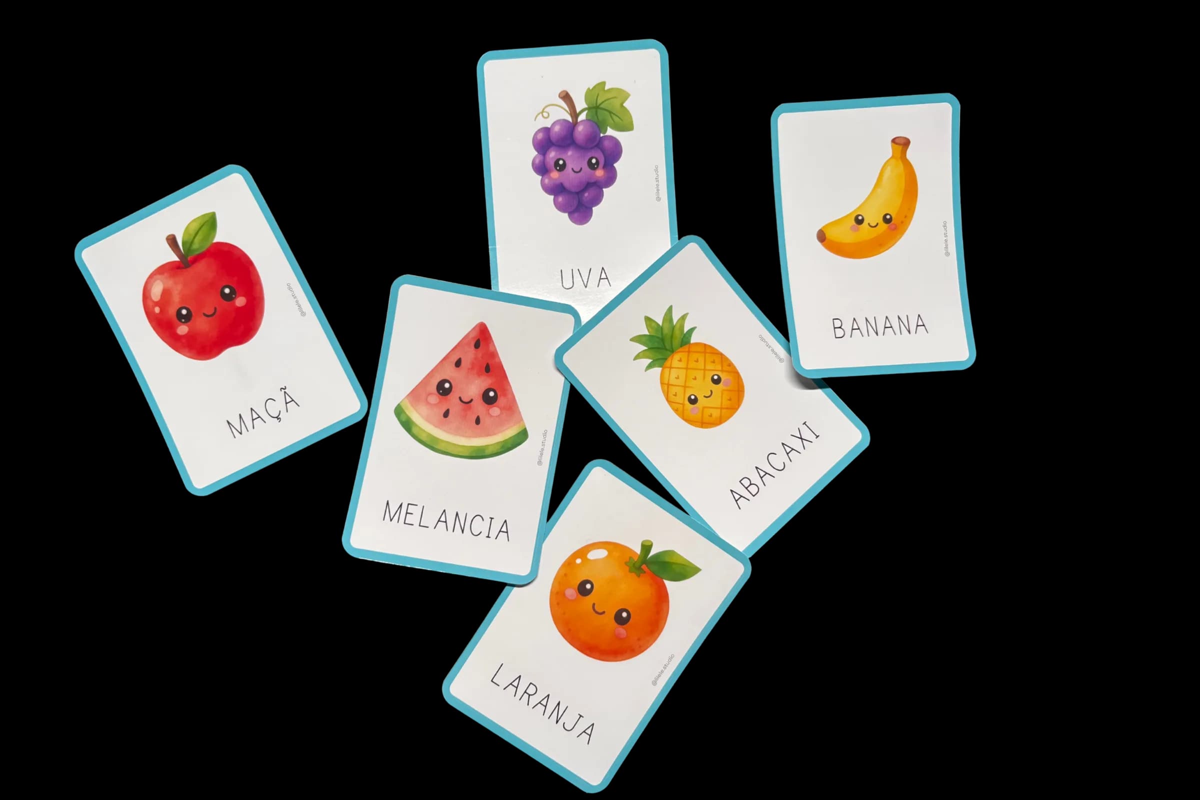 Composição de cartas ilustradas com frutas, espalhadas sobre o papel